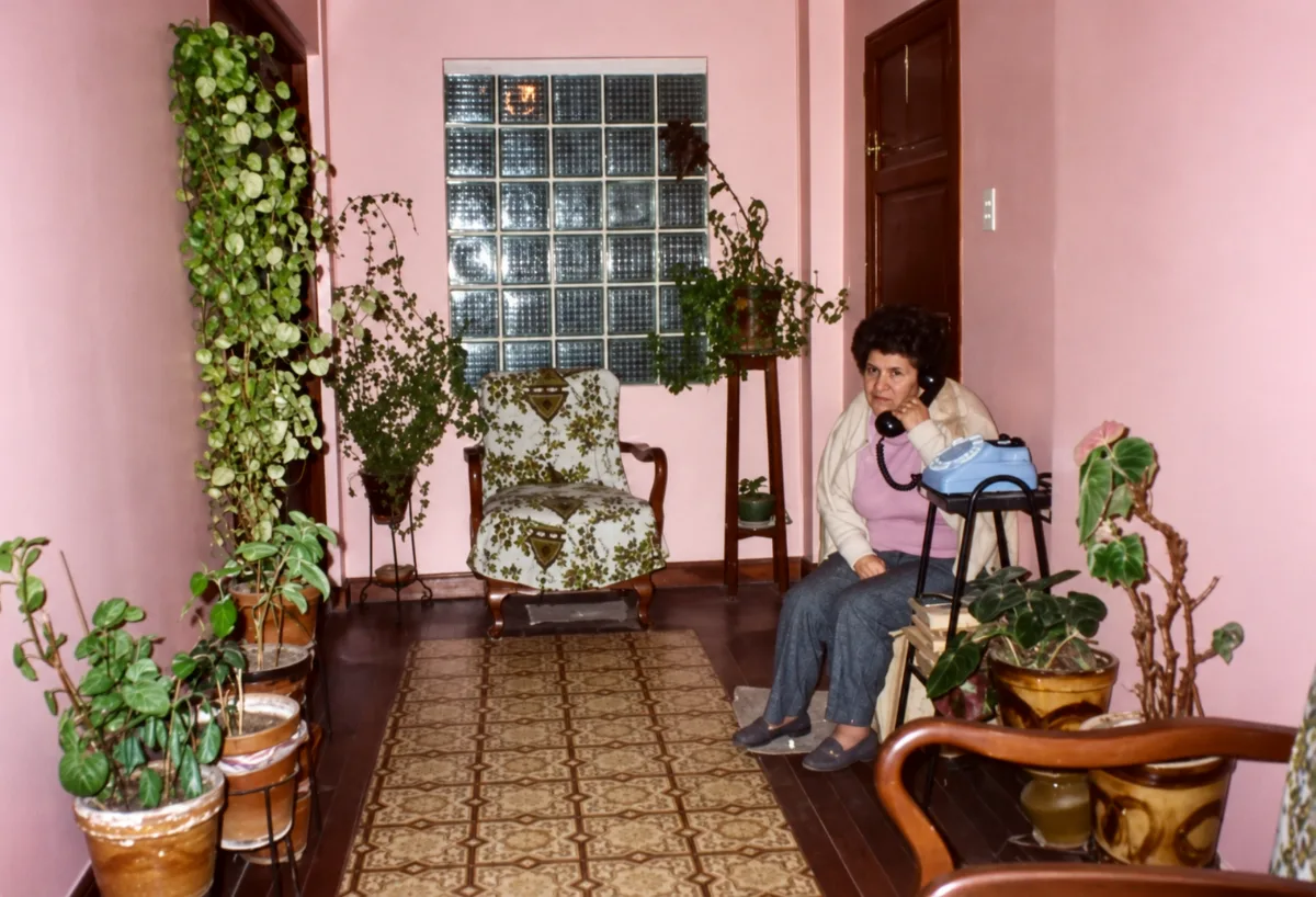 Yolanda al teléfono en el pasillo de su casa lleno de plantas