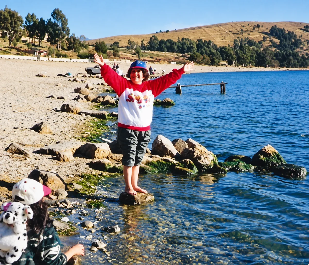 Yolanda con los brazos abiertos a orillas del Lago Titicaca
